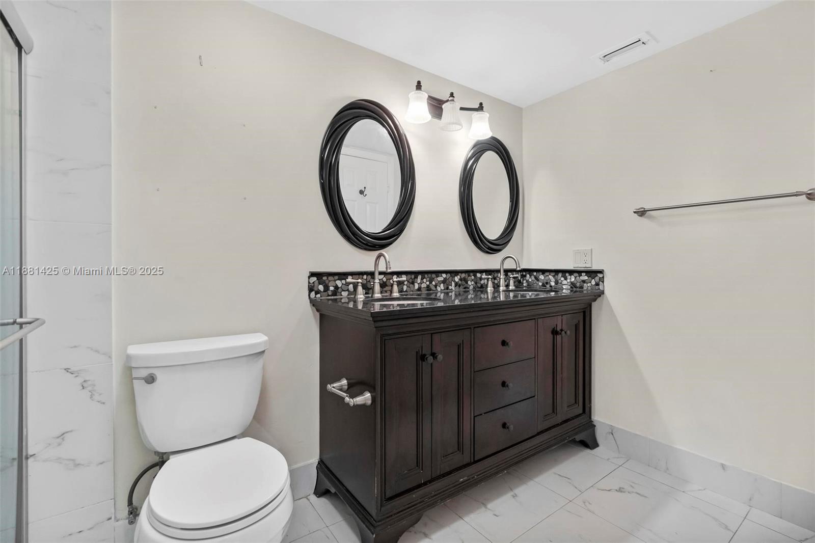 5119 Oak Hill Road Delray Beach, FL 33484 - Photo 22 of 48 a bathroom with a toilet a sink and a mirror