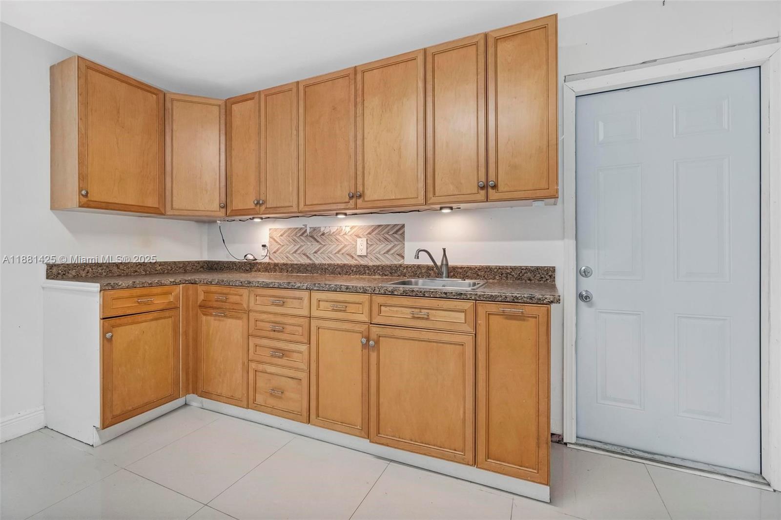 5119 Oak Hill Road Delray Beach, FL 33484 - Photo 32 of 48 a kitchen with granite countertop cabinets and white appliances