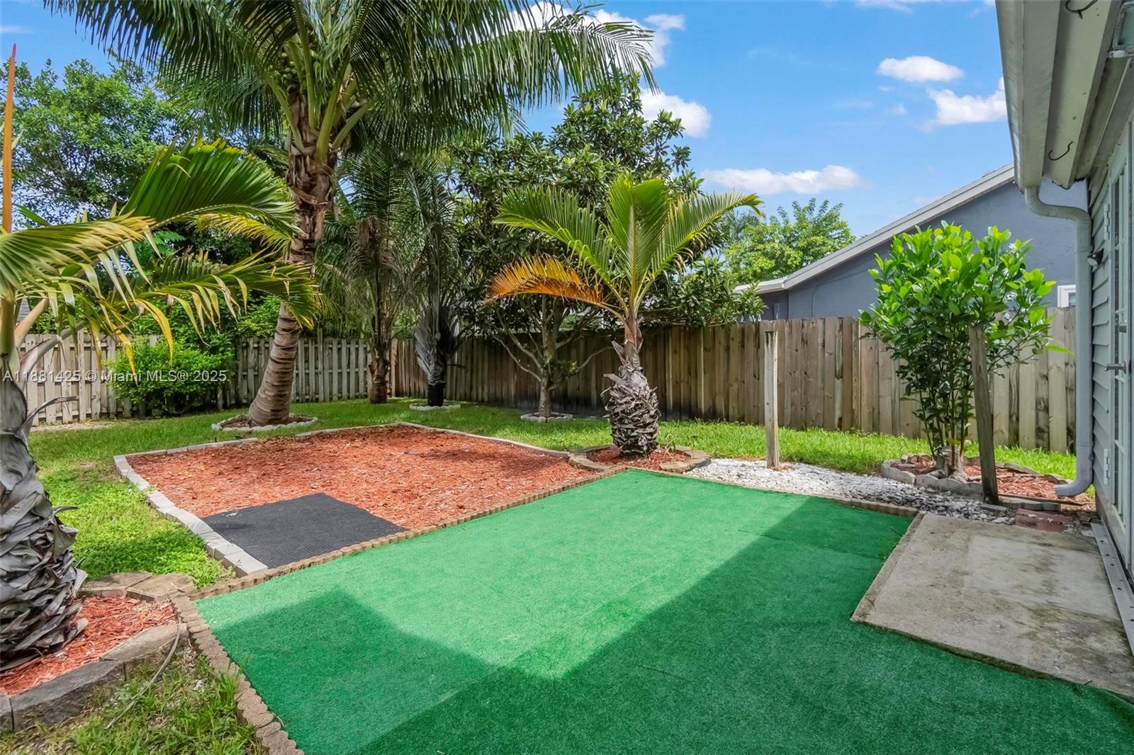 5119 Oak Hill Road Delray Beach, FL 33484 - Photo 42 of 48 a view of a backyard with a garden and palm trees