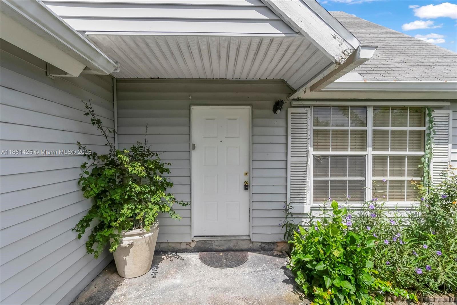 5119 Oak Hill Road Delray Beach, FL 33484 - Photo 5 of 48 a front view of a house with a potted plant