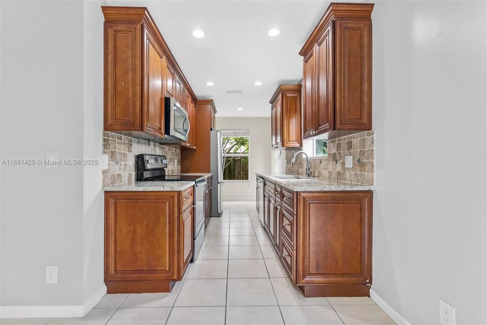 5119 Oak Hill Road Delray Beach, FL 33484 - Photo 10 of 48 a kitchen with stainless steel appliances granite countertop a refrigerator and a sink