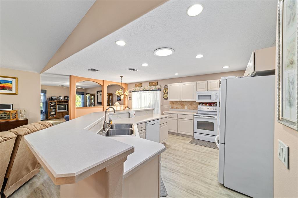 15680 Southwest 13th Circle Ocala, FL 34473 - Photo 33 of 75 a kitchen with stainless steel appliances kitchen island granite countertop a refrigerator and a stove top oven