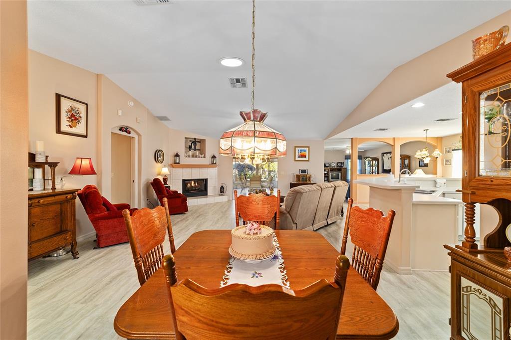 15680 Southwest 13th Circle Ocala, FL 34473 - Photo 38 of 75 a dining room with furniture a fireplace and a chandelier