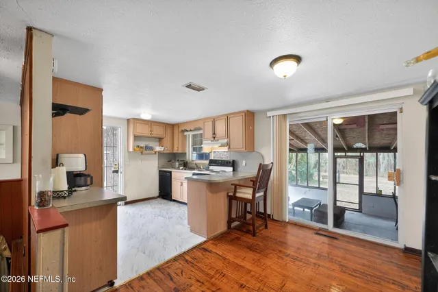 a view of a kitchen with kitchen island a large window cabinets and stainless steel appliances