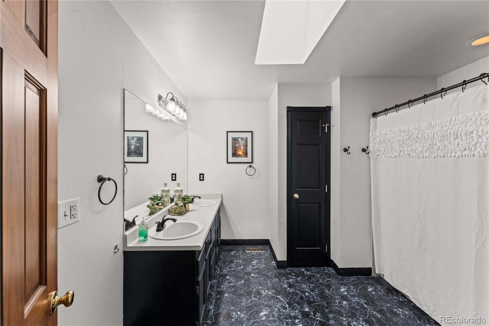 4763 Barnes Road Colorado Springs, CO 80917 - Photo 14 of 21 a bathroom with a sink and mirror with shower