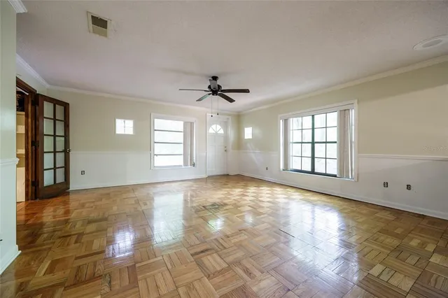 a view of a refrigerator in kitchen and an empty room