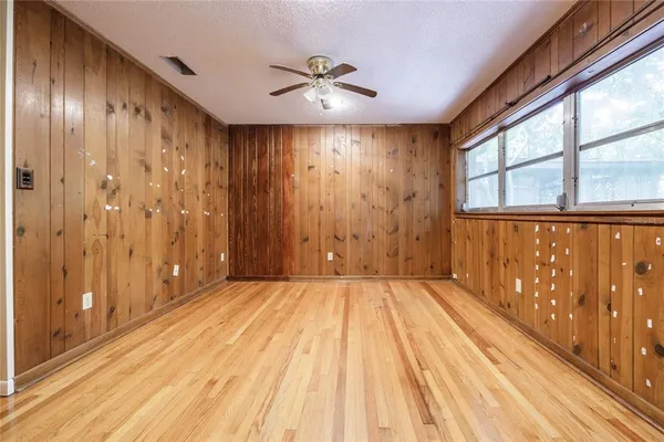 a view of an empty room with a window and wooden floor