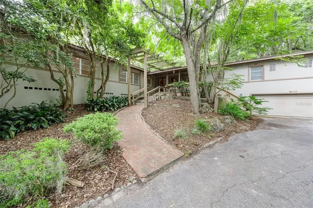 a view of a livingroom with a fireplace a ceiling fan and window