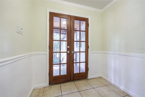 a view of an empty room with a window and kitchen view