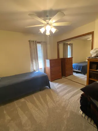 a bedroom with a bed and dresser with mirror