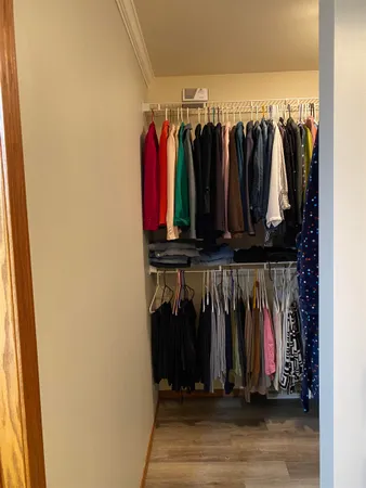a view of walk in closet with clothes