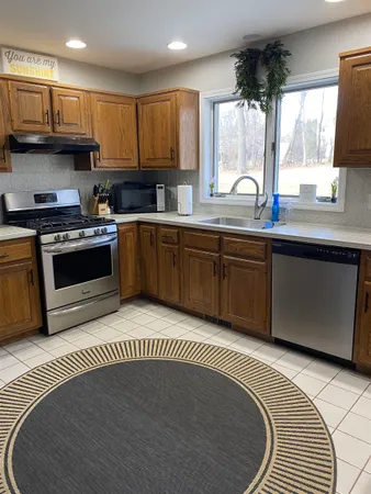 a kitchen with stainless steel appliances granite countertop a stove a sink and a microwave