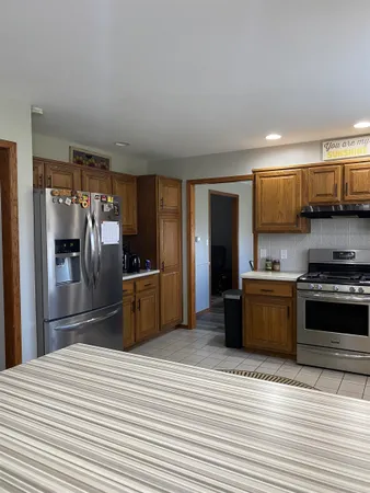 a kitchen with stainless steel appliances kitchen island granite countertop a refrigerator and a stove top oven