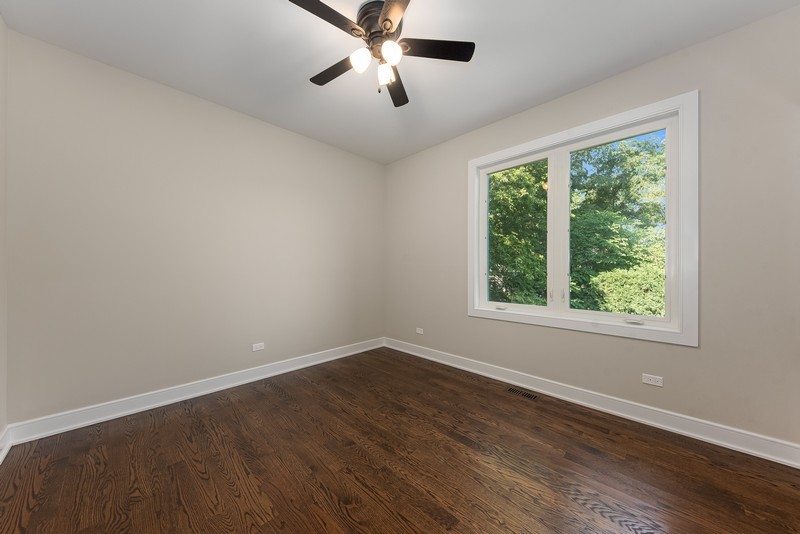 5700 Wolf Road Western Springs, IL 60558 - Photo 15 of 39 a view of an empty room with wooden floor and a window