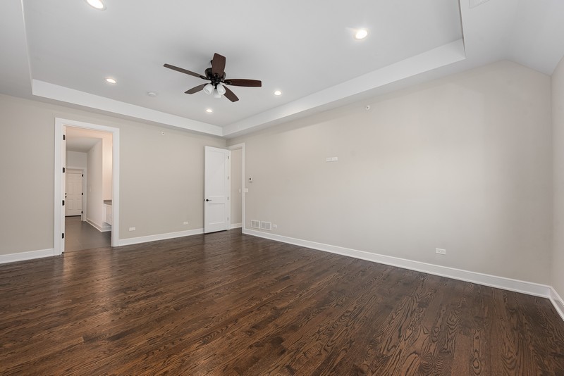 5700 Wolf Road Western Springs, IL 60558 - Photo 21 of 39 a view of an empty room with wooden floor and a ceiling fan