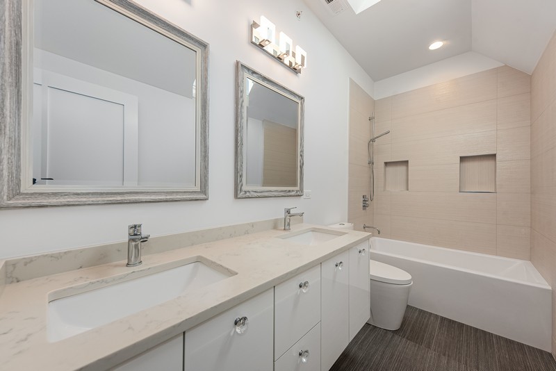 5700 Wolf Road Western Springs, IL 60558 - Photo 27 of 39 a bathroom with a double vanity sink a mirror and a bathtub
