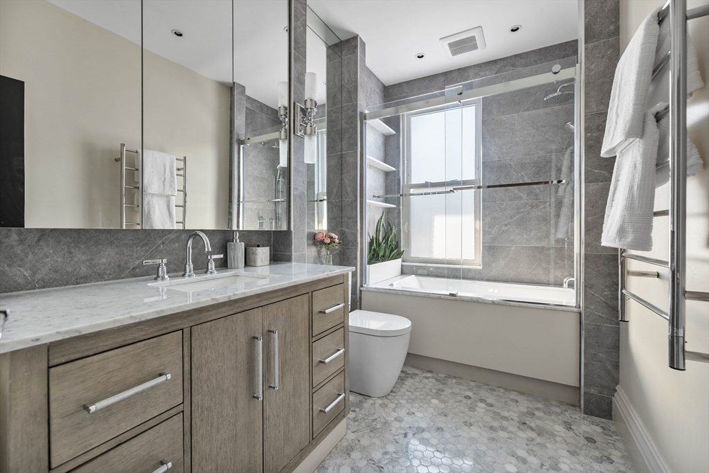 93 Third Street, Unit 93 Cambridge, MA 02141 - Photo 24 of 42 a bathroom with a granite countertop sink toilet and shower