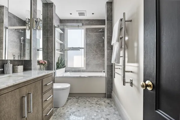 a bathroom with a granite countertop sink toilet and shower