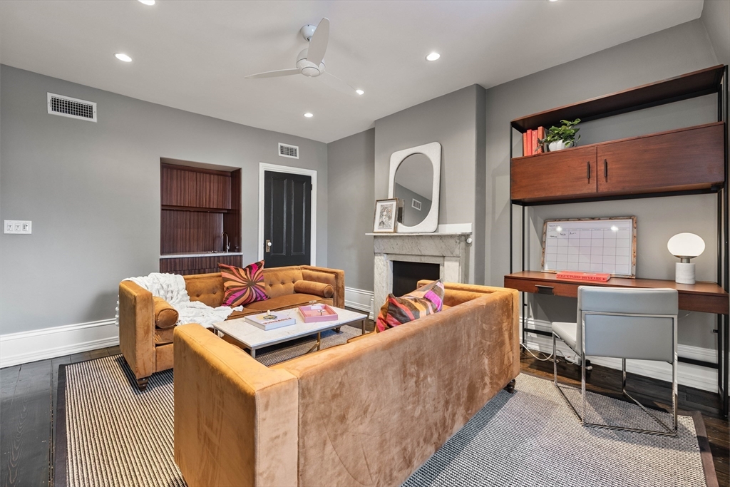 93 Third Street, Unit 93 Cambridge, MA 02141 - Photo 27 of 42 a living room with furniture a fireplace and a flat screen tv