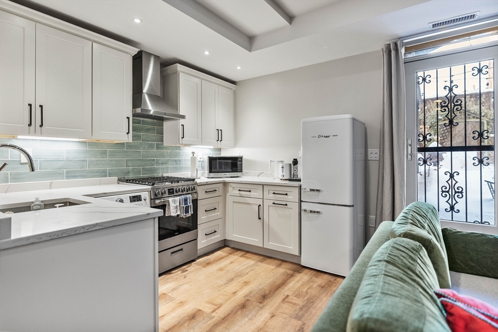 93 Third Street, Unit 93 Cambridge, MA 02141 - Photo 34 of 42 a kitchen with white cabinets and white appliances