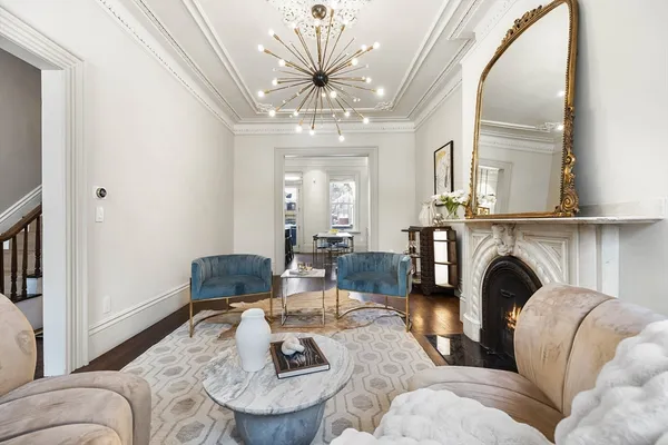 a living room with furniture a fireplace and a chandelier