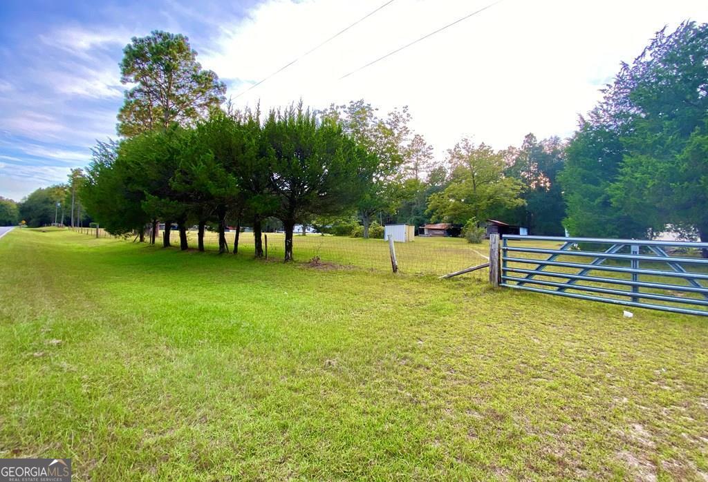 5873 Ben Carter Road Baxley, GA 31513 - Photo 1 of 1 a view of a swimming pool with a bench and trees