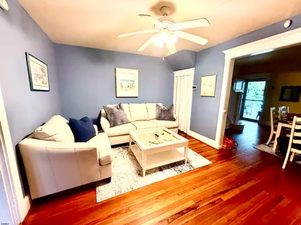 a living room with furniture and a wooden floor