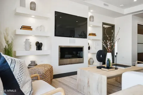 a living room with furniture a flat screen tv and a fireplace