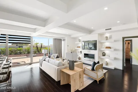 a living room with fireplace furniture and a large window