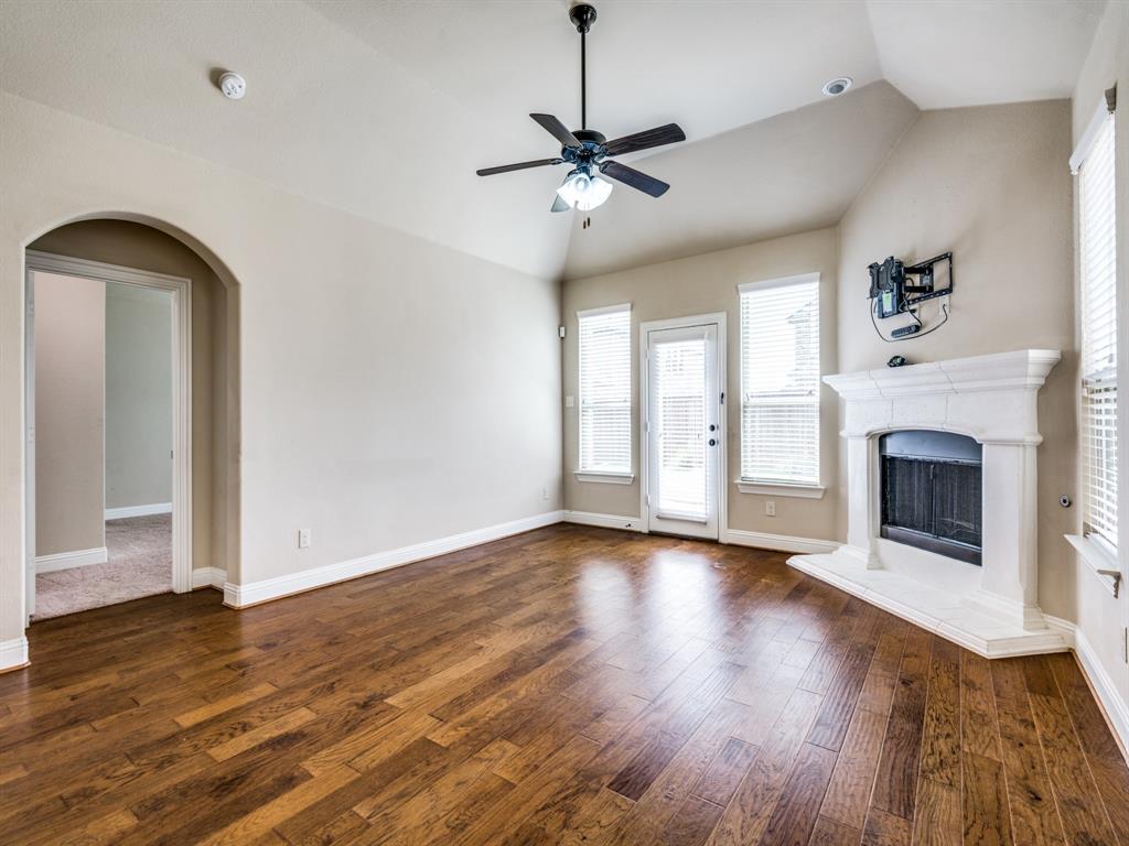 820 Callcott Street McKinney, TX 75072 - Photo 11 of 22 a view of empty room with wooden floor and fireplace