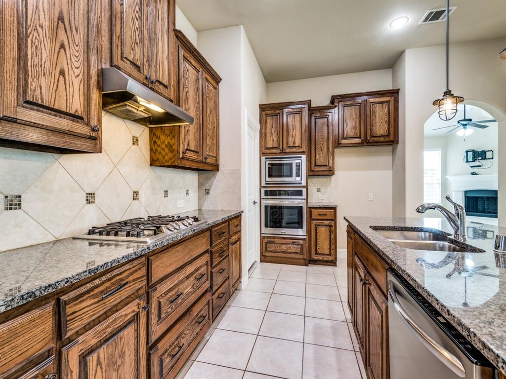 820 Callcott Street McKinney, TX 75072 - Photo 10 of 22 a kitchen with stainless steel appliances granite countertop a stove and a sink
