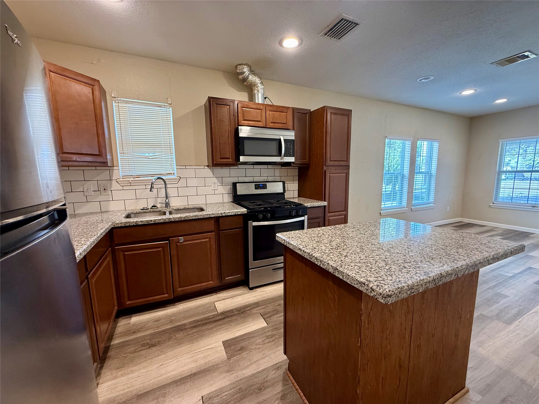 429 West 2nd Street Freeport, TX 77541 - Photo 8 of 49 a kitchen with a stove a sink and a refrigerator