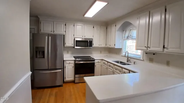 a kitchen with granite countertop a refrigerator stove and sink