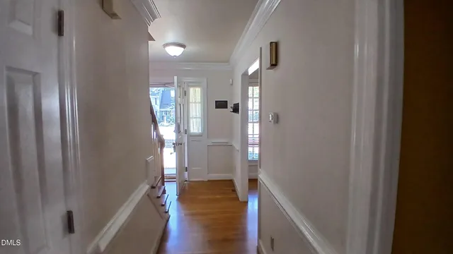 a view of a hallway with wooden floor and stairs