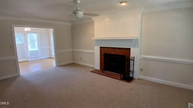 an empty room with a fireplace and fan
