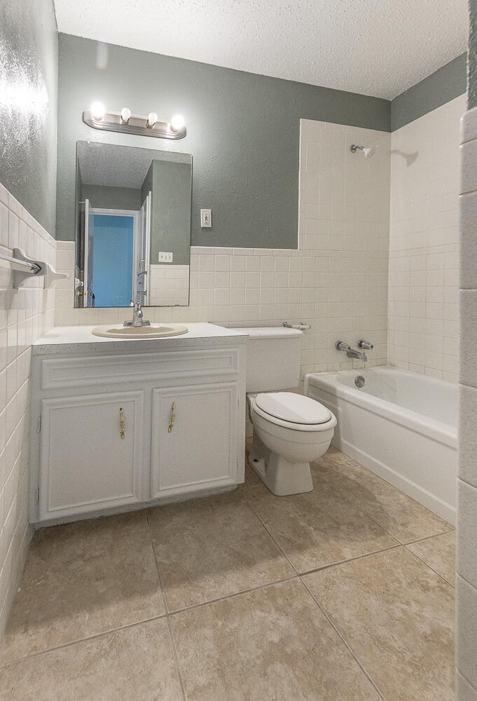 5405 49th Street Lubbock, TX 79414 - Photo 16 of 25 a bathroom with a sink a toilet and a mirror