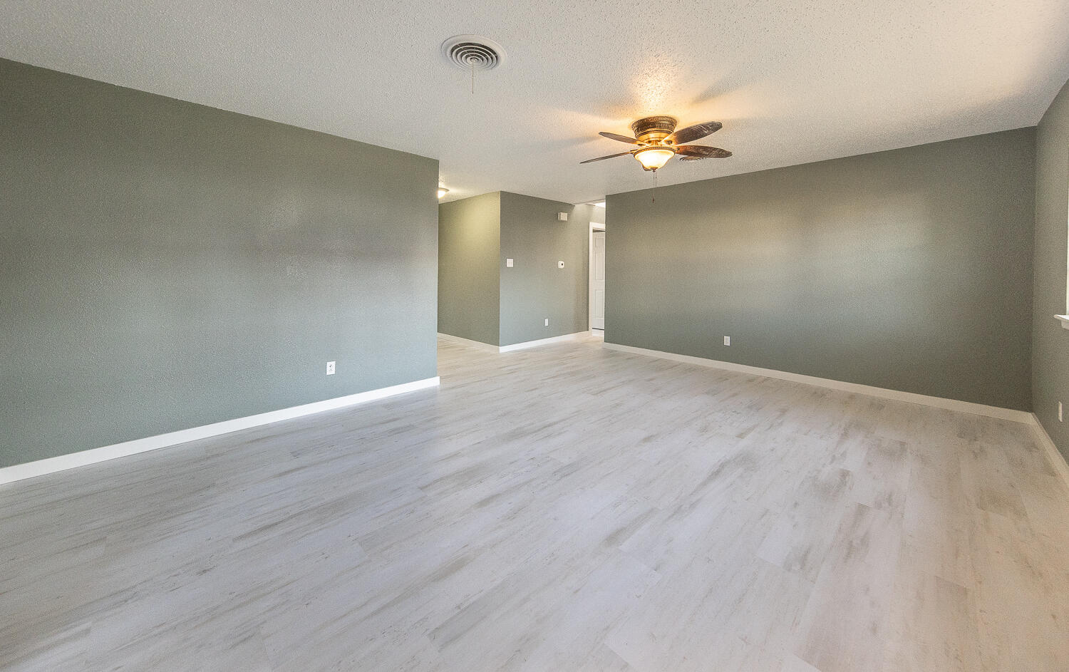 5405 49th Street Lubbock, TX 79414 - Photo 6 of 25 wooden floor in an empty room with a chandelier fan