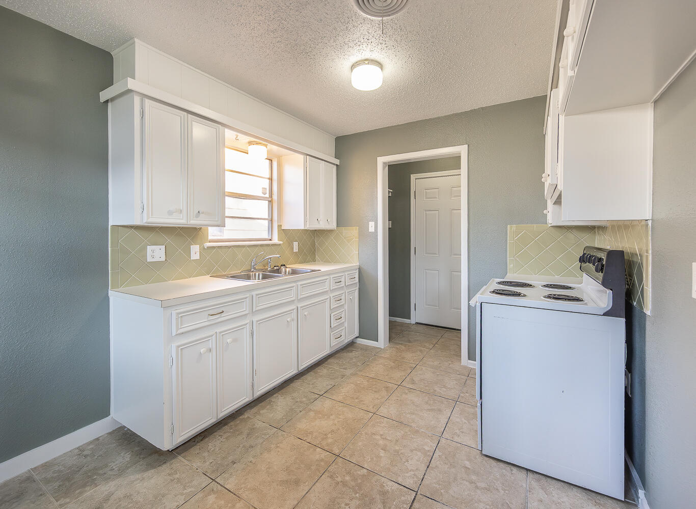 5405 49th Street Lubbock, TX 79414 - Photo 9 of 25 a kitchen with a stove sink and cabinets