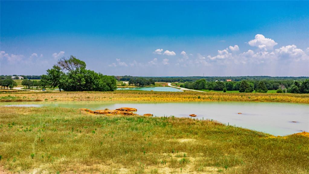 1789 Brumelow Road Whitesboro, TX 76273 - Photo 17 of 30 Expansive natural landscape featuring multiple bodies of water, open fields, and scattered mature trees