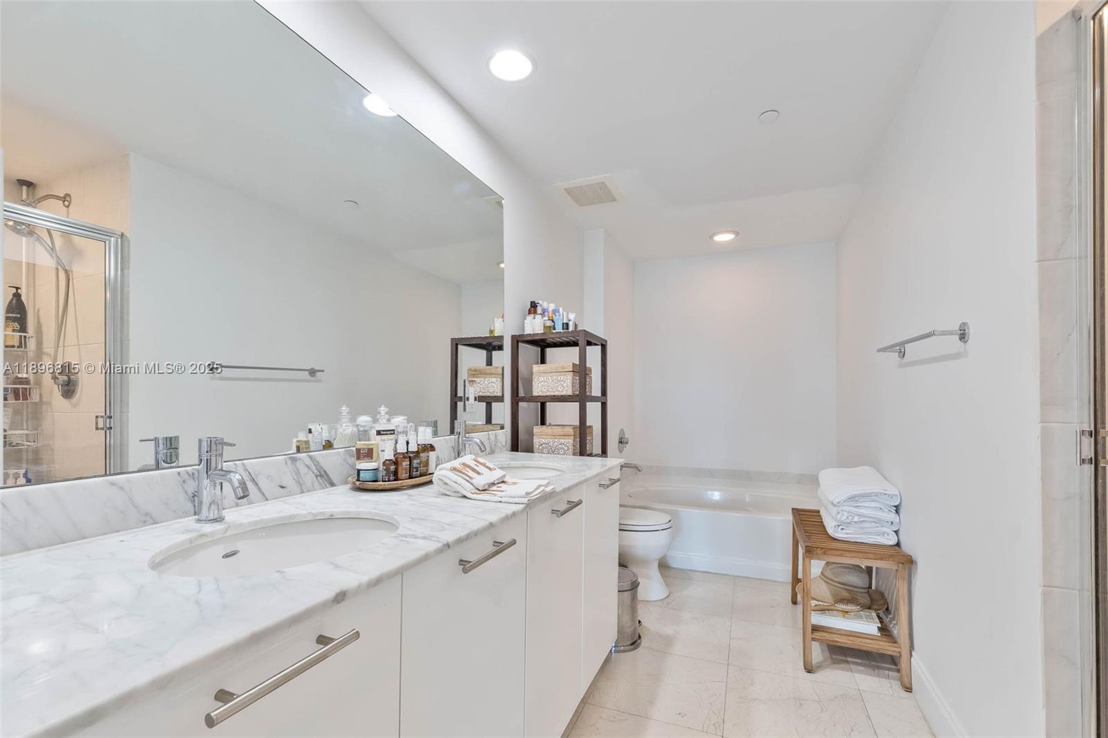 951 Brickell Avenue, Unit 1606 Miami, FL 33131 - Photo 16 of 30 a bathroom with a double vanity sink toilet and a mirror