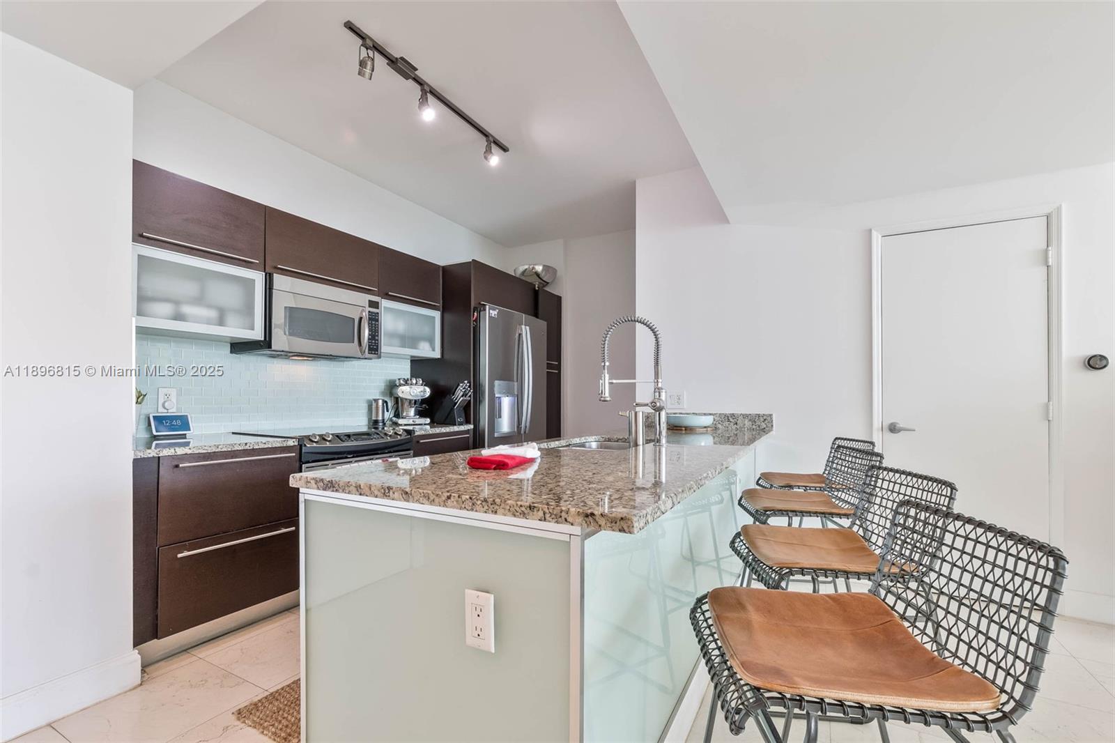 951 Brickell Avenue, Unit 1606 Miami, FL 33131 - Photo 19 of 30 a kitchen with stainless steel appliances granite countertop a sink refrigerator and cabinets