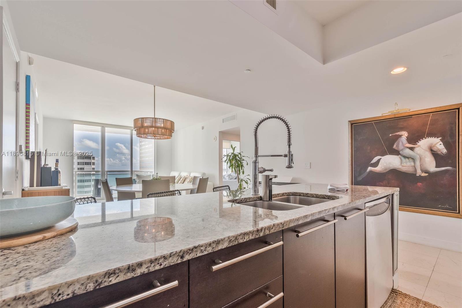 951 Brickell Avenue, Unit 1606 Miami, FL 33131 - Photo 21 of 30 a kitchen with granite countertop a sink and cabinets