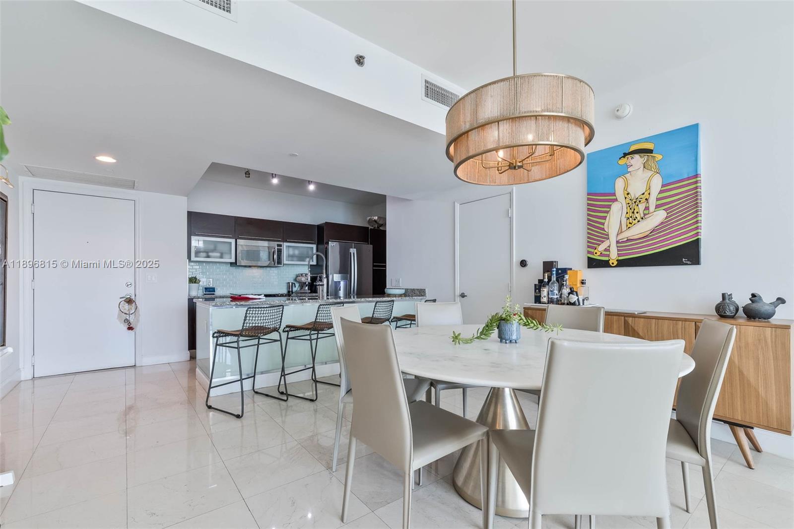 951 Brickell Avenue, Unit 1606 Miami, FL 33131 - Photo 3 of 30 a kitchen with stainless steel appliances a dining table chairs and white cabinets