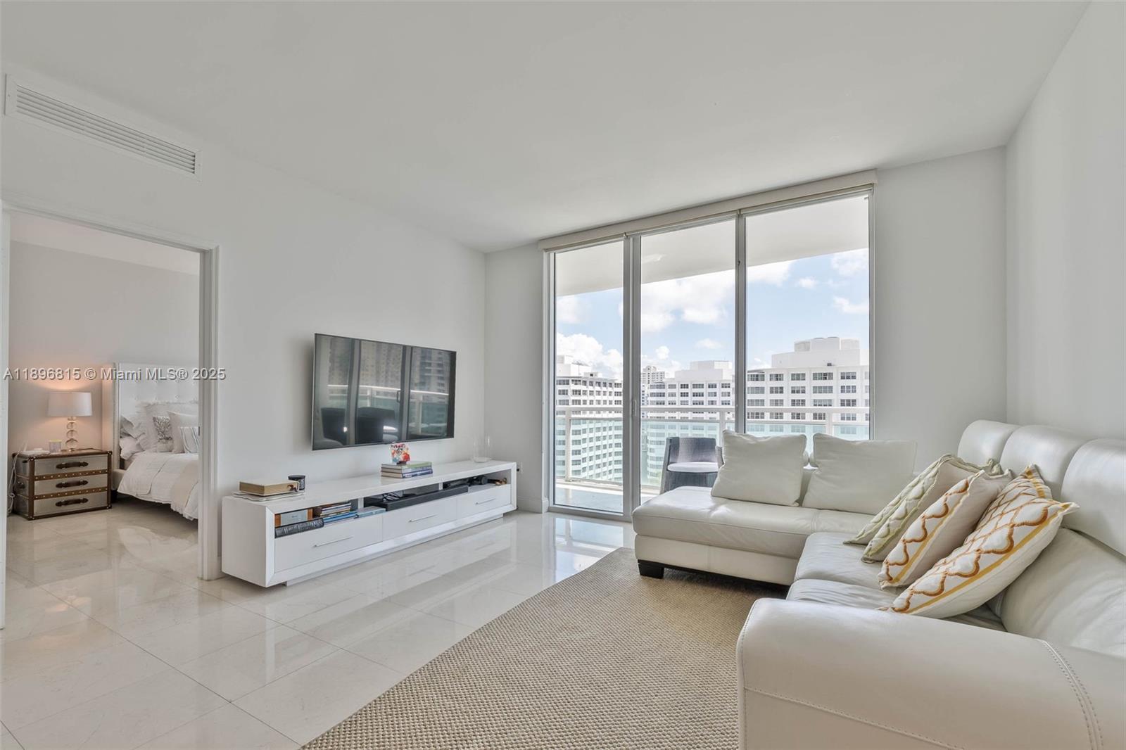 951 Brickell Avenue, Unit 1606 Miami, FL 33131 - Photo 5 of 30 a living room with furniture and a flat screen tv