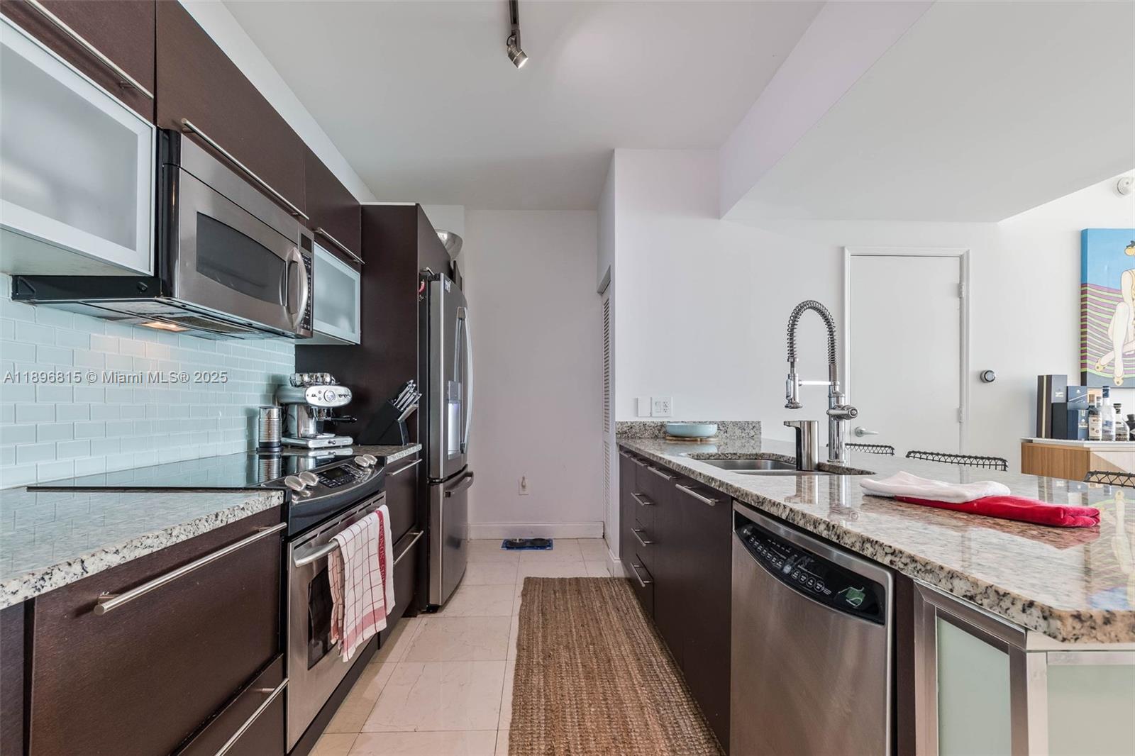 951 Brickell Avenue, Unit 1606 Miami, FL 33131 - Photo 10 of 30 a kitchen with stainless steel appliances granite countertop a sink stove and cabinets