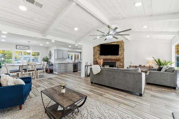 a kitchen with stainless steel appliances a stove a sink dishwasher and a flat screen tv