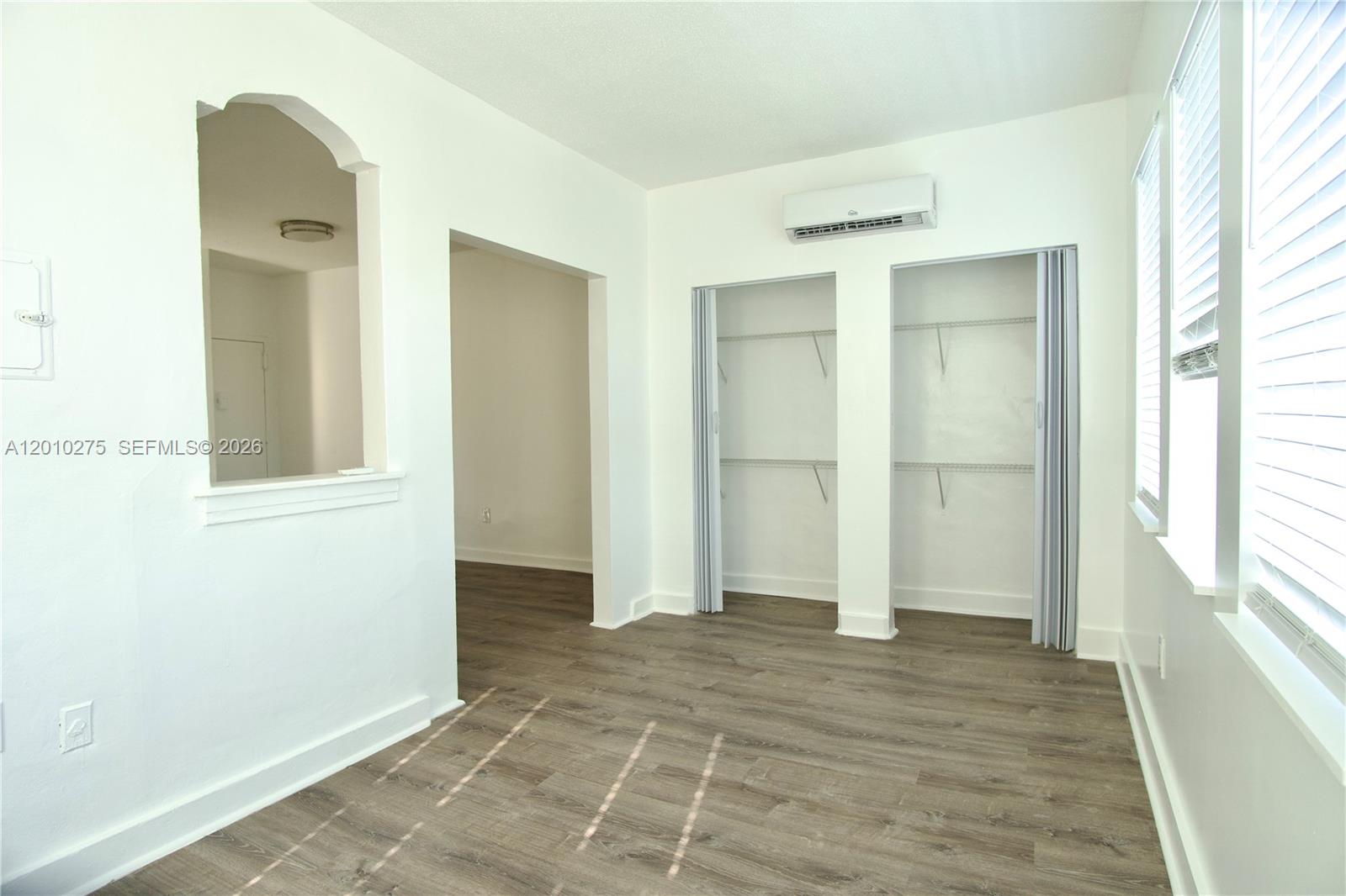 501 Southwest 6th Court, Unit 319 Miami, FL 33130 - Photo 1 of 15 a view of an empty room with window and wooden floor
