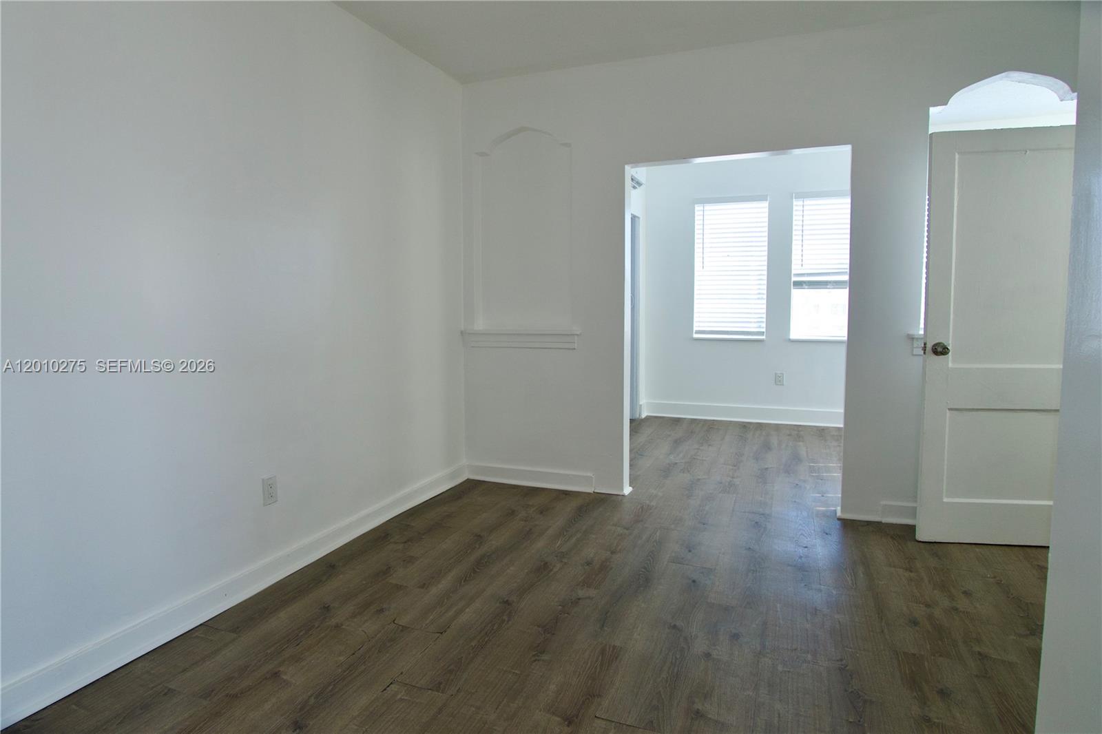 501 Southwest 6th Court, Unit 319 Miami, FL 33130 - Photo 11 of 15 an empty room with wooden floor and windows