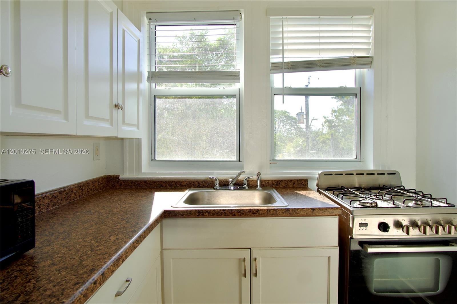 501 Southwest 6th Court, Unit 319 Miami, FL 33130 - Photo 15 of 15 a kitchen with granite countertop a sink and a window