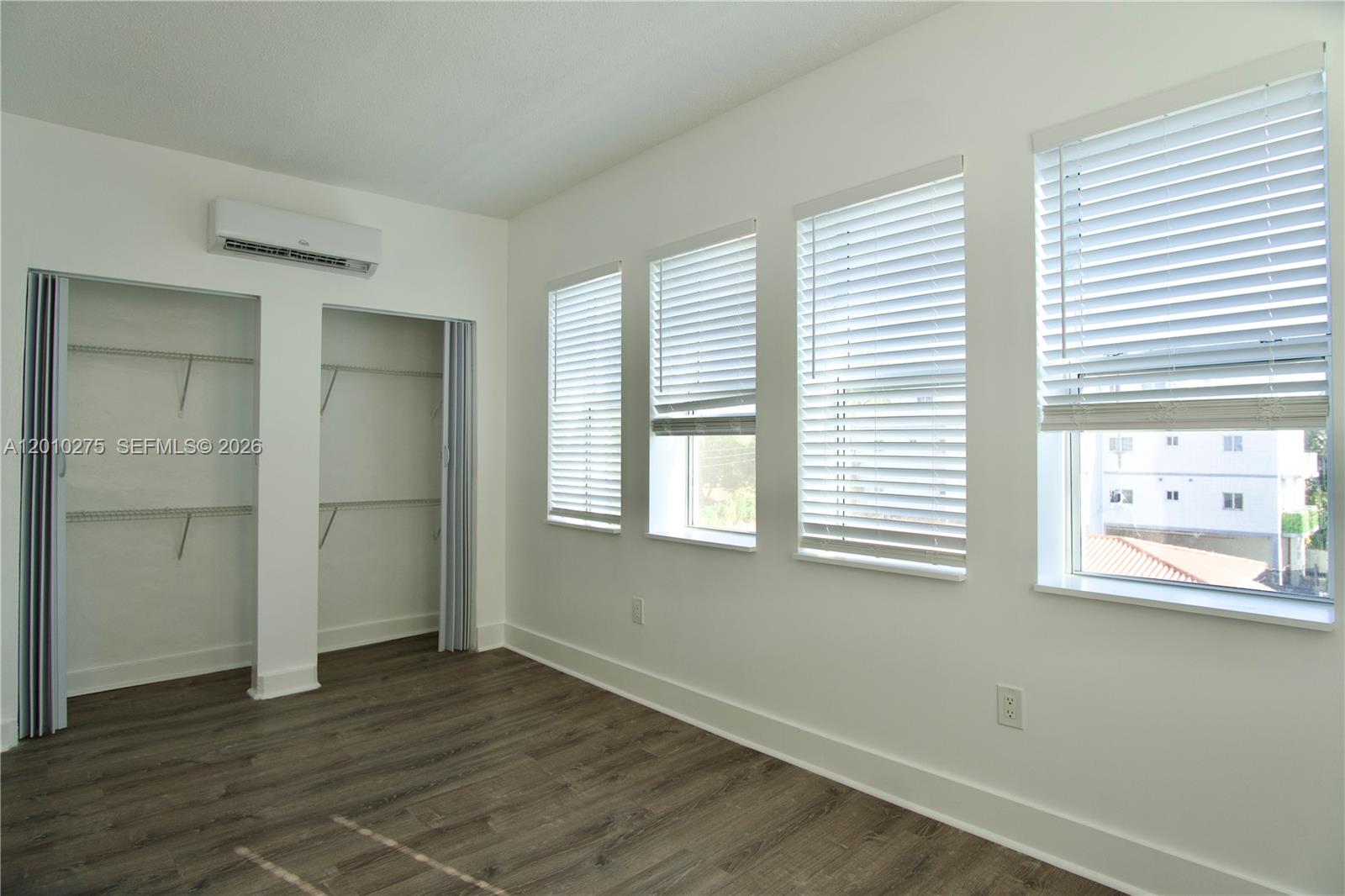501 Southwest 6th Court, Unit 319 Miami, FL 33130 - Photo 2 of 15 a view of an empty room with wooden floor and a window